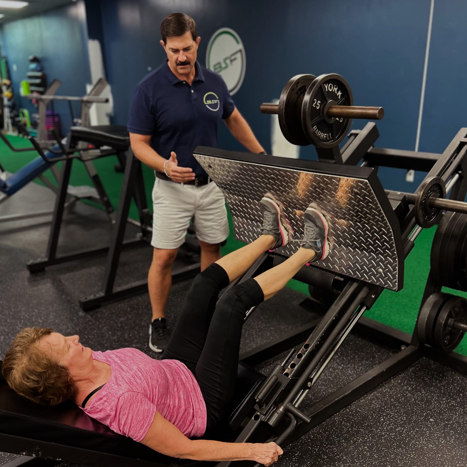 Scott McCarthy coaching a client through a leg press at Balance Strength and Fitness